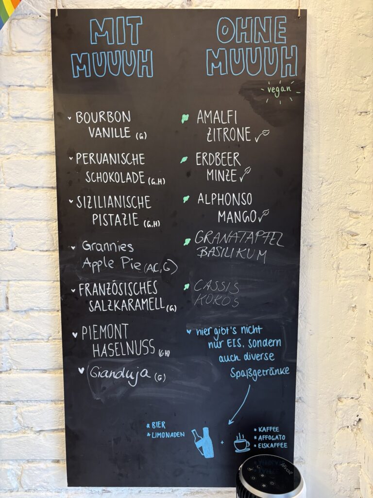 Schwarze Tafel in einem Eisgeschäft mit Eissorten unter den Überschriften mit Muuuh und ohne Muuuh